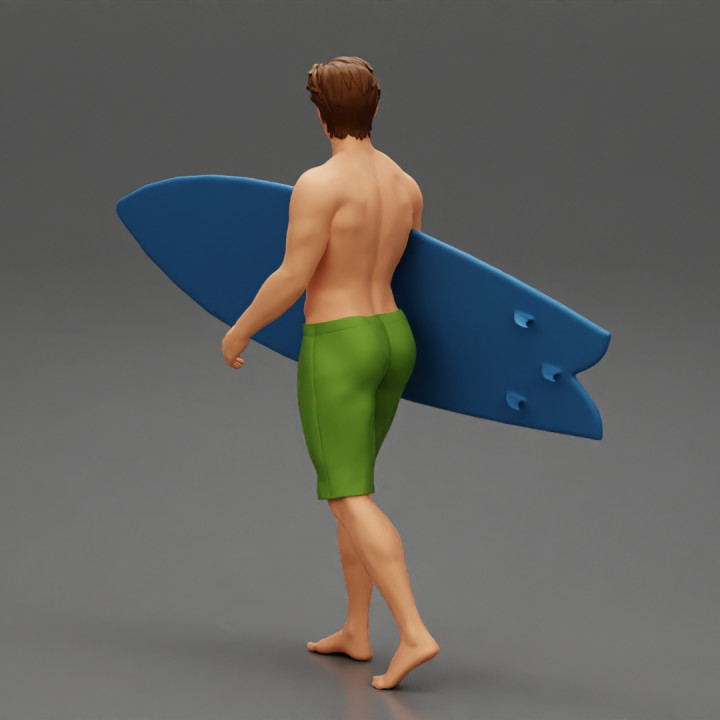 young man holding surfboard walking on the sea image