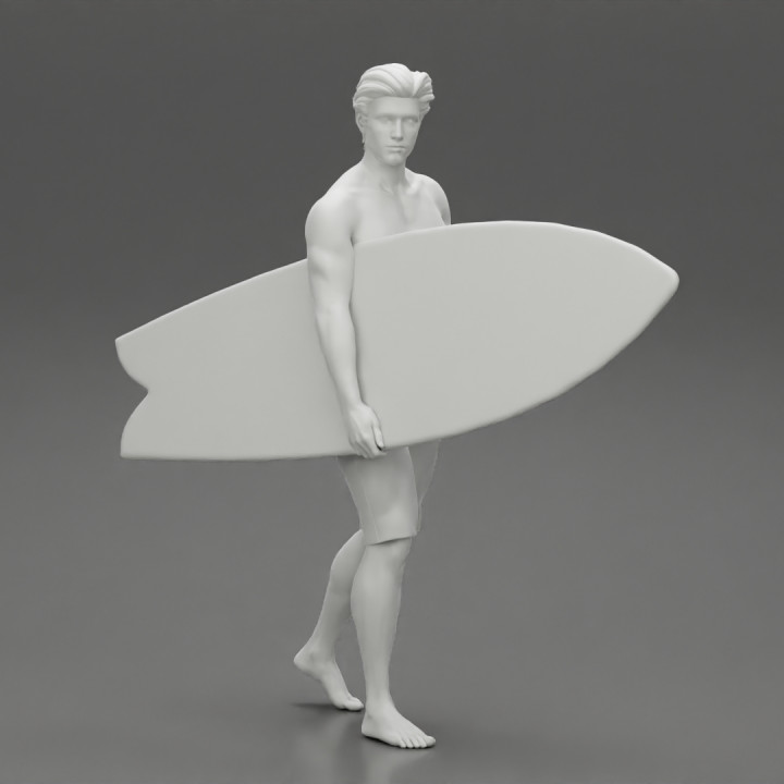 young man holding surfboard walking on the sea image