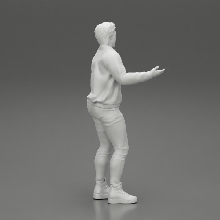 young man standing and explaining with hands image