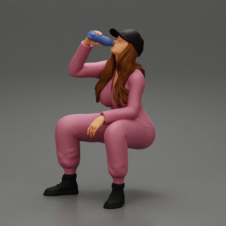 mechanic girl sitting and drinking water in suit and cap image