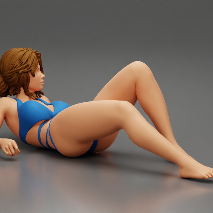 Sexy girl in a bikini lying on beach image