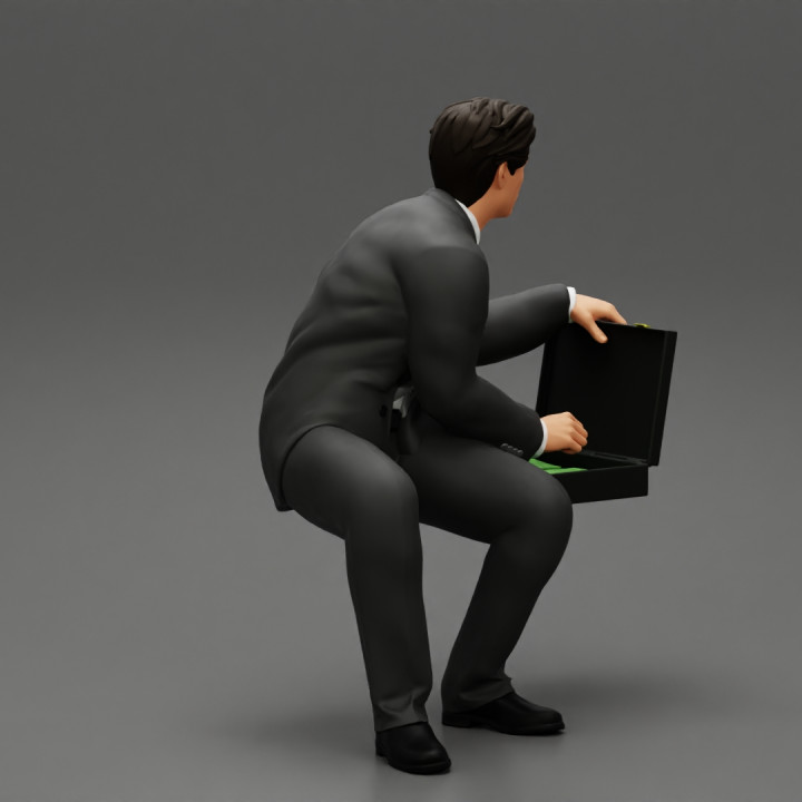 businessman sitting and holding briefcase of money image