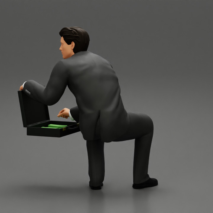 businessman sitting and holding briefcase of money image