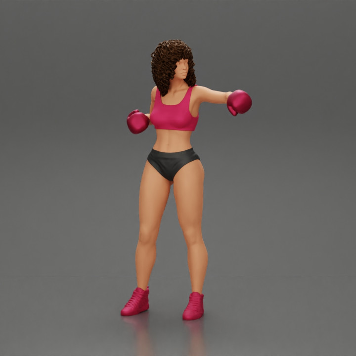 black woman in boxing gloves with curly hair ready to finish off her opponent image