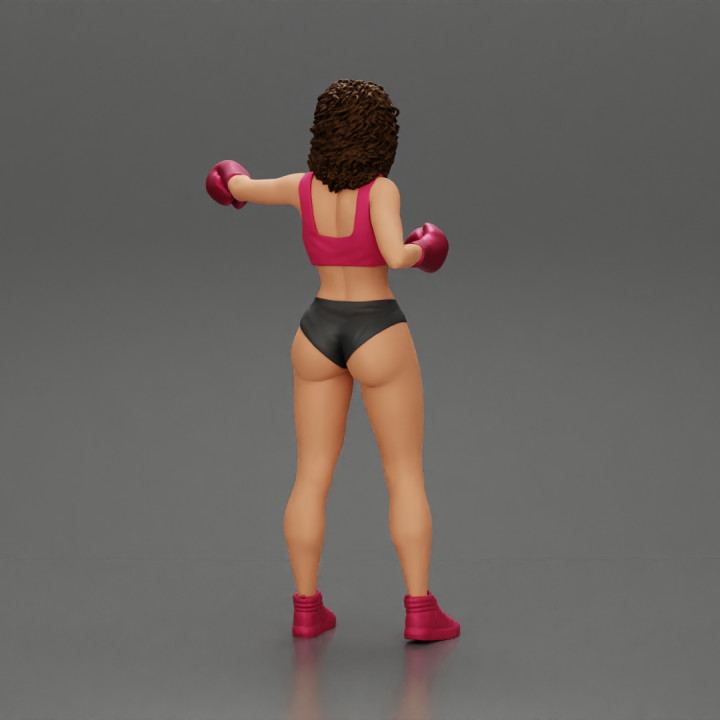 black woman in boxing gloves with curly hair ready to finish off her opponent image