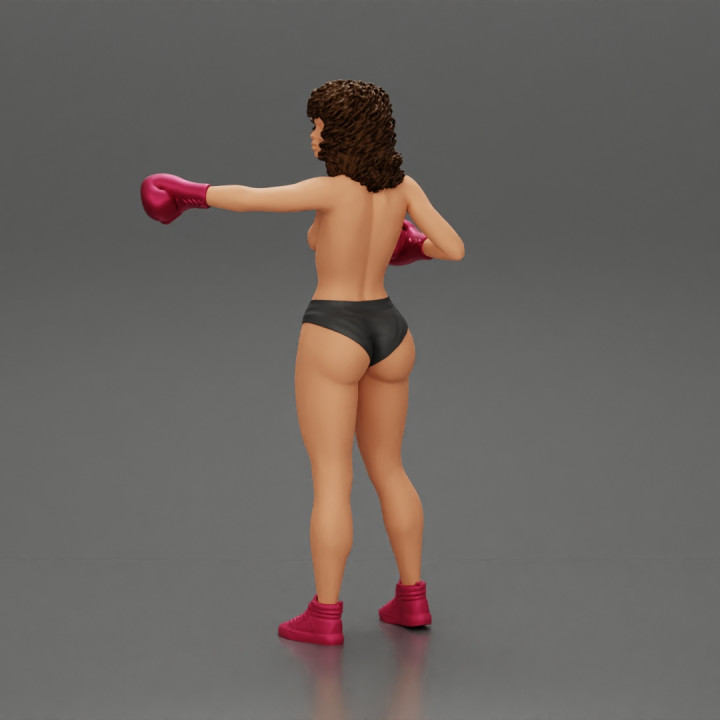 black naked breasts woman in boxing gloves with curly hair ready to finish off her opponent image