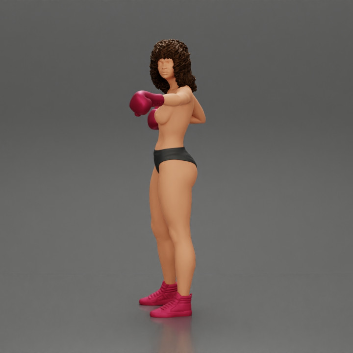 black naked breasts woman in boxing gloves with curly hair ready to finish off her opponent image