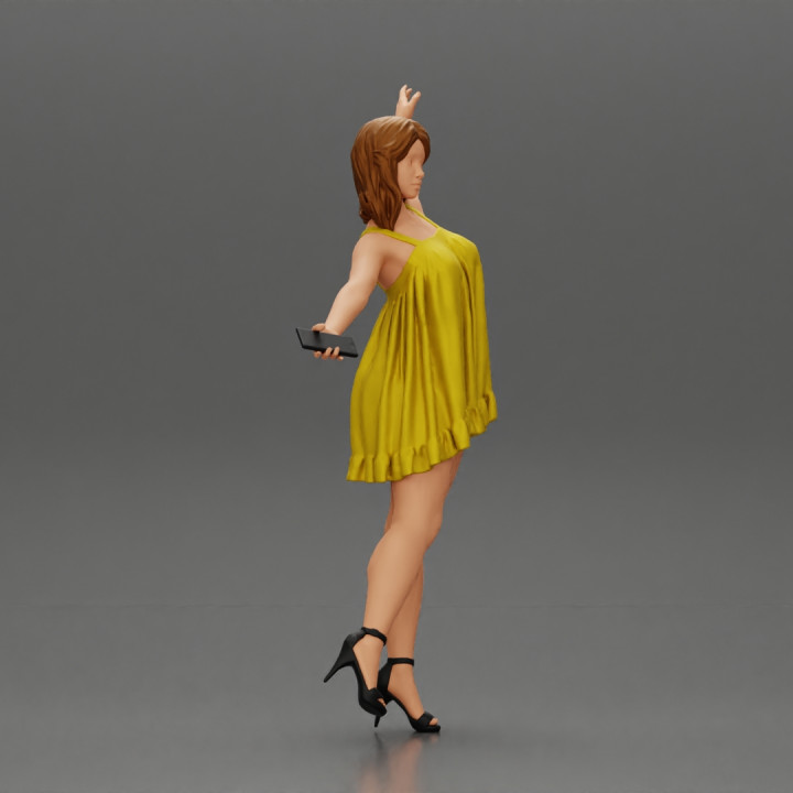 Happy Young Woman in dress and heels Standing on One Leg holding phone image