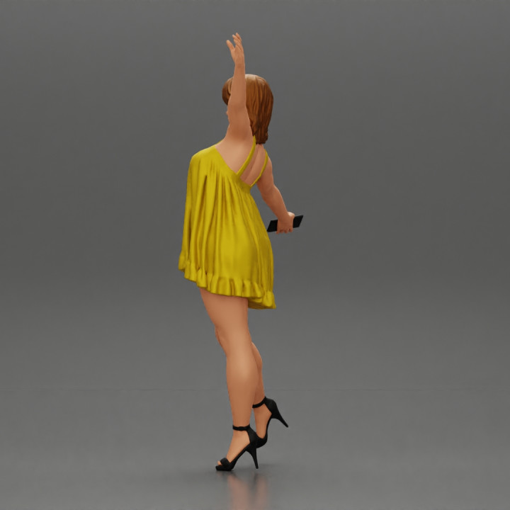 Happy Young Woman in dress and heels Standing on One Leg holding phone image