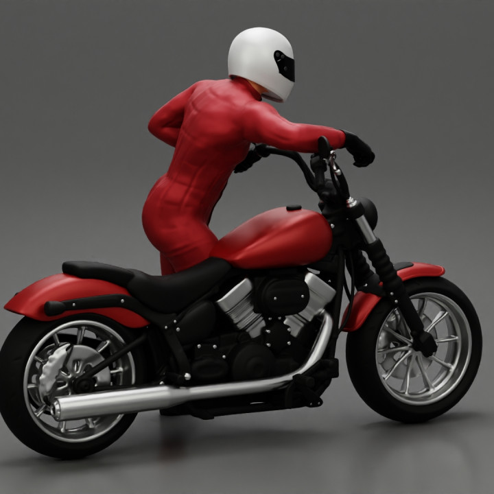Motorbiker standing pushing his motorbike image
