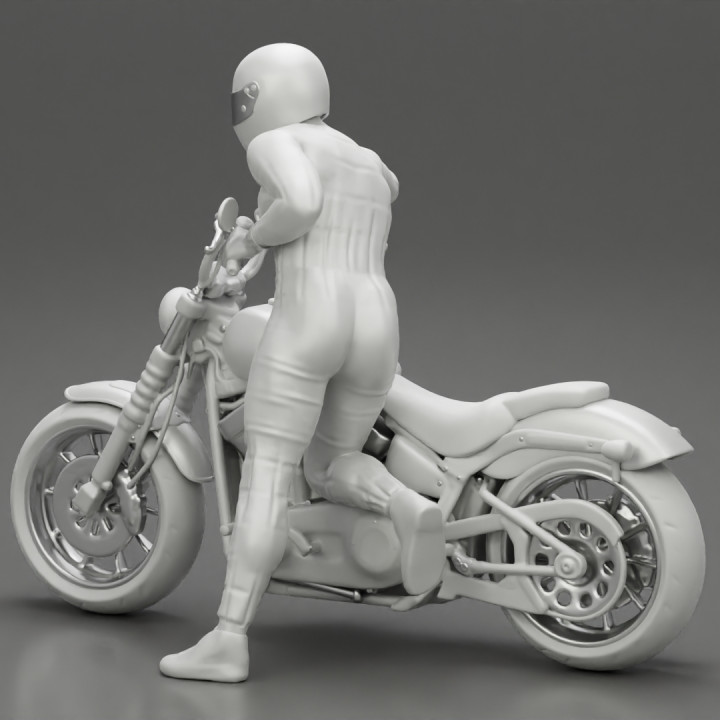 Motorbiker standing pushing his motorbike image