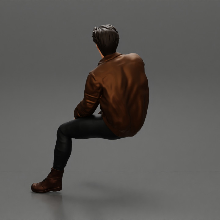 Handsome Young Man in Leather Jacket Looking Away while Sitting image