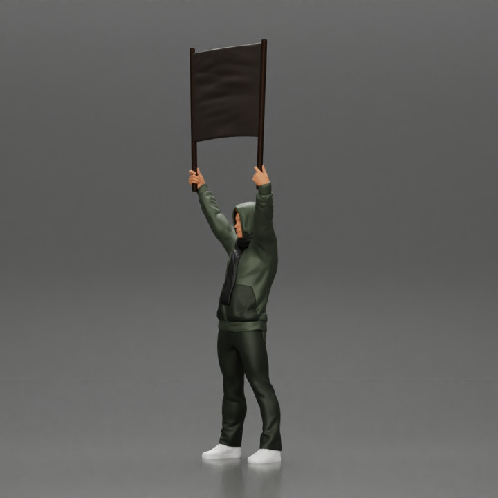 man in a hoodie and scarf is holding a banner image