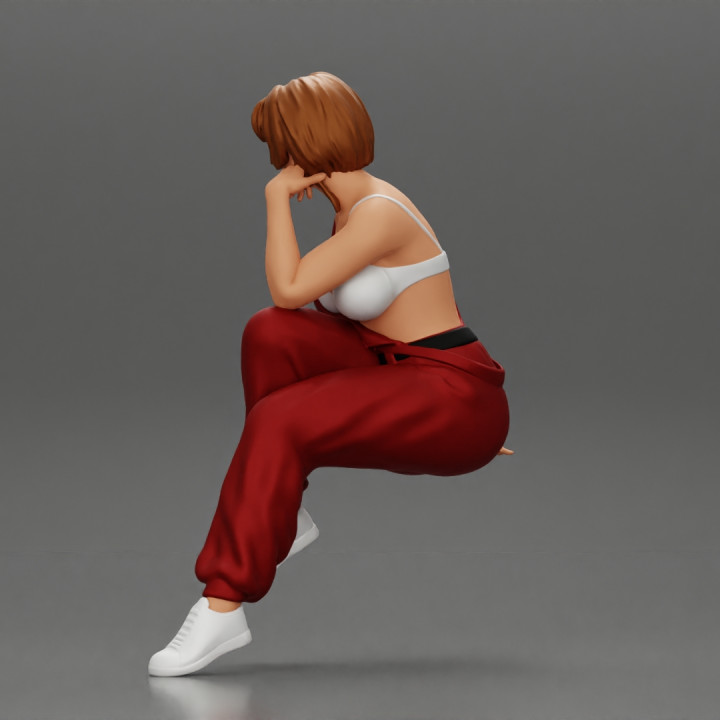 3d Printable Young Woman Sitting Taking Off Her Bib Overalls By