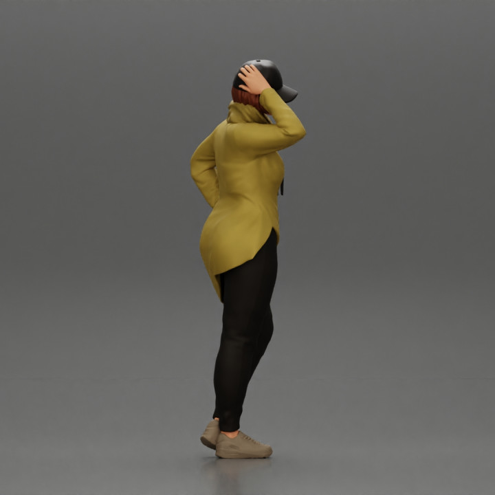 Asian girl in a neck hoodie and cap is standing and thinking image