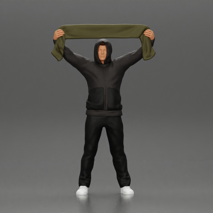 man in a hoodie supporting and holding a scarf image