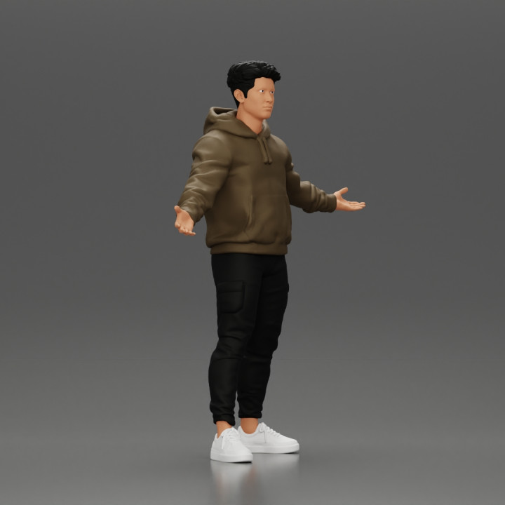 Asian Man Standing in Hoodie with Raised Hands image