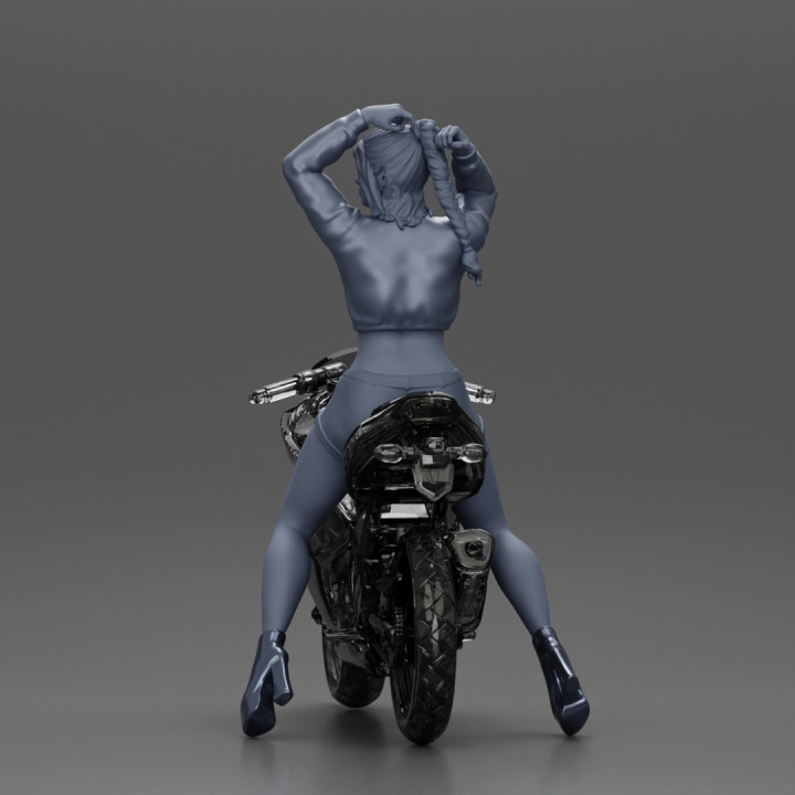 attractive girl on the motorbike stopping and putting hands on hair image